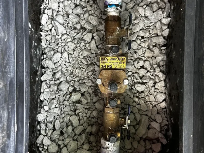 Backflow prevention device installed in a valve box on a gravel bed