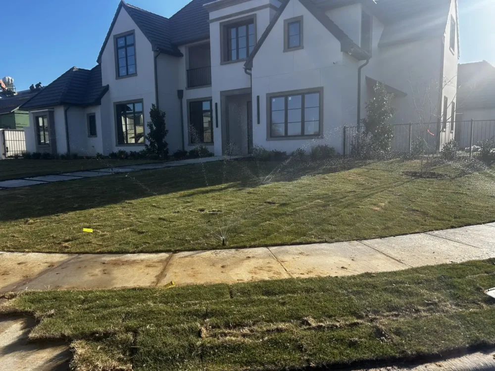 Newly installed sprinkler system and fresh sod in front of a new DFW home