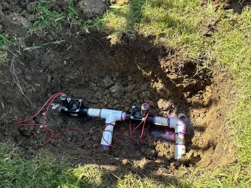 Replacement irrigation valves installed in an open dig in the lawn
