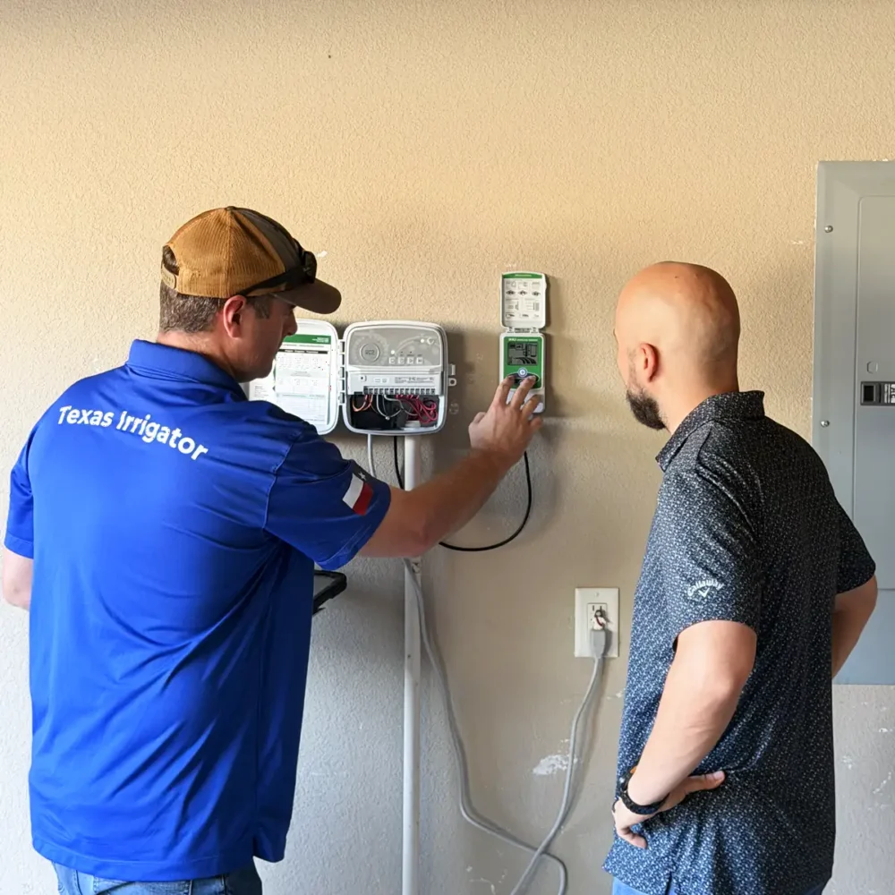 Technician explaining the irrigation controller settings to a homeowner in the garage