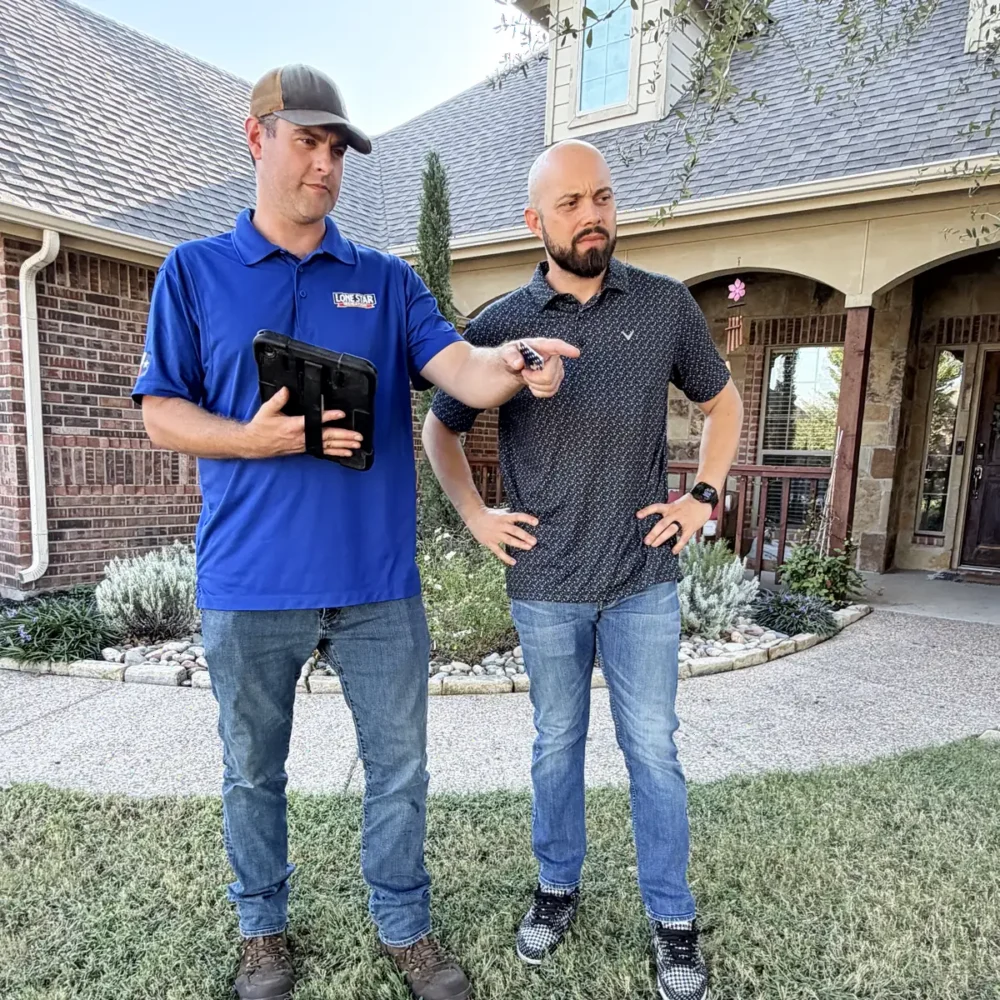 Technician pointing out a sprinkler problem to a homeowner during a system check
